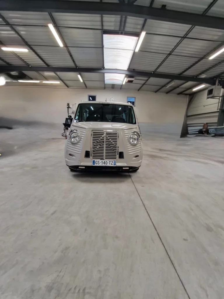 Vue de face d'un véhicule de pompes funèbres blanc dans un garage.