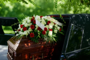 Corbillard ouvert transportant un cercueil recouvert de roses.
